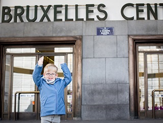 Un petit garçon pose devant la gare de Bruxelles-Central