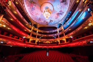 Salle de l'Opéra Royal de Liège avec les sièges en velours rouge et les gradins