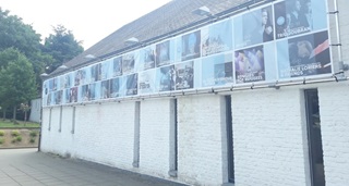 De witte gevel van de Ferme du Biéreau aangekleed met een spandoek met de culturele agenda