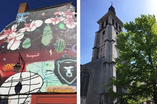 De gevel van een gebouw bedekt met een street art fresco en kerktoren in de zon